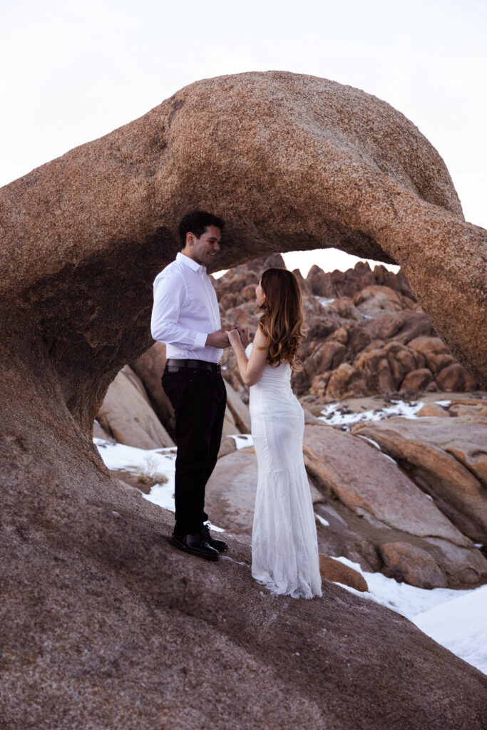 couple holding hand under an arch