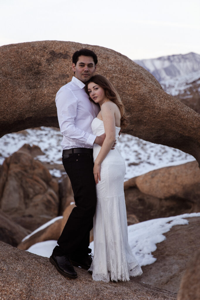 couple posing in front of and arch in Alabama hills