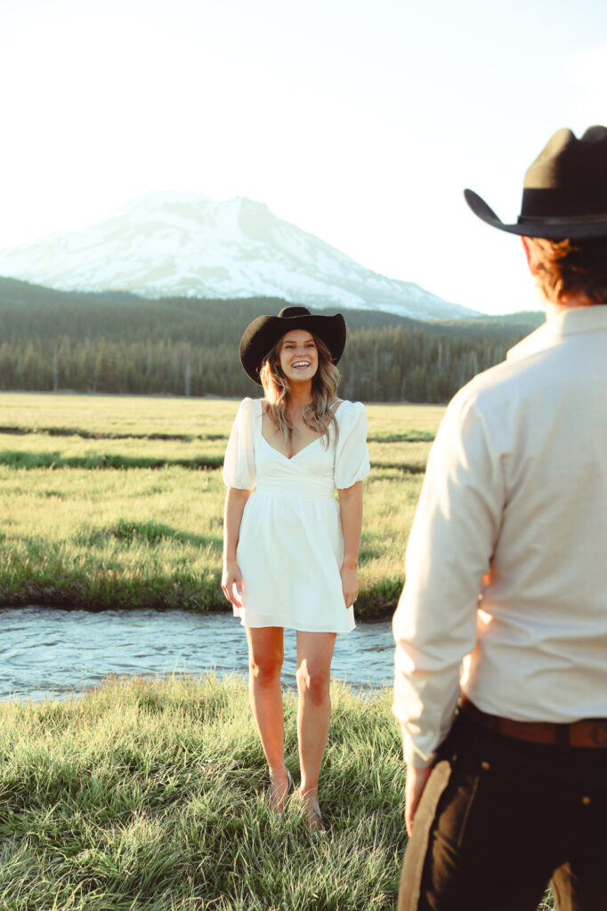 A boy admiring his fiance in a cowboy hat for their engagement shoot