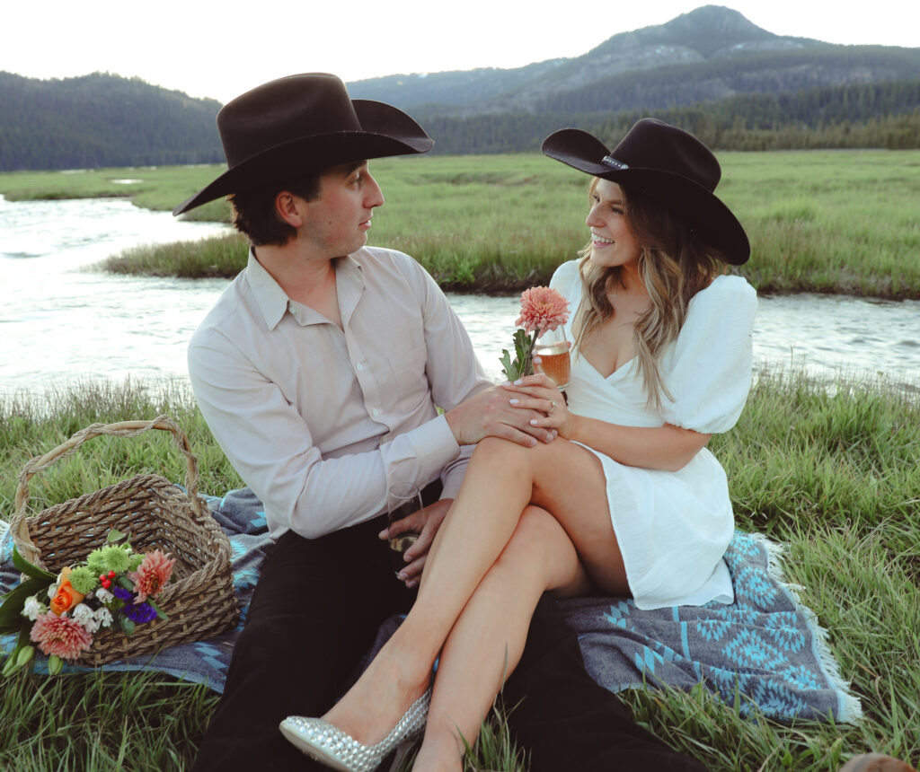 A guy giving a girl a flower for their engagement photo shoot